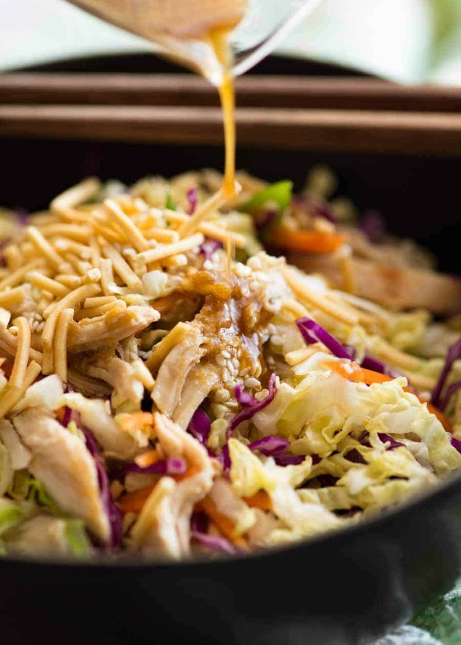 Asian Dressing being poured over Chinese Chicken Salad