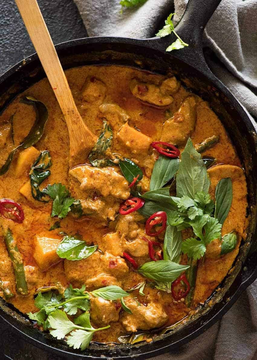 Overhead photo of Thai Red Curry with Chicken in a black skillet, fresh off the stove.