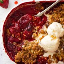 Close up of Strawberry Crumble in a white pudding dish, fresh out of the oven.