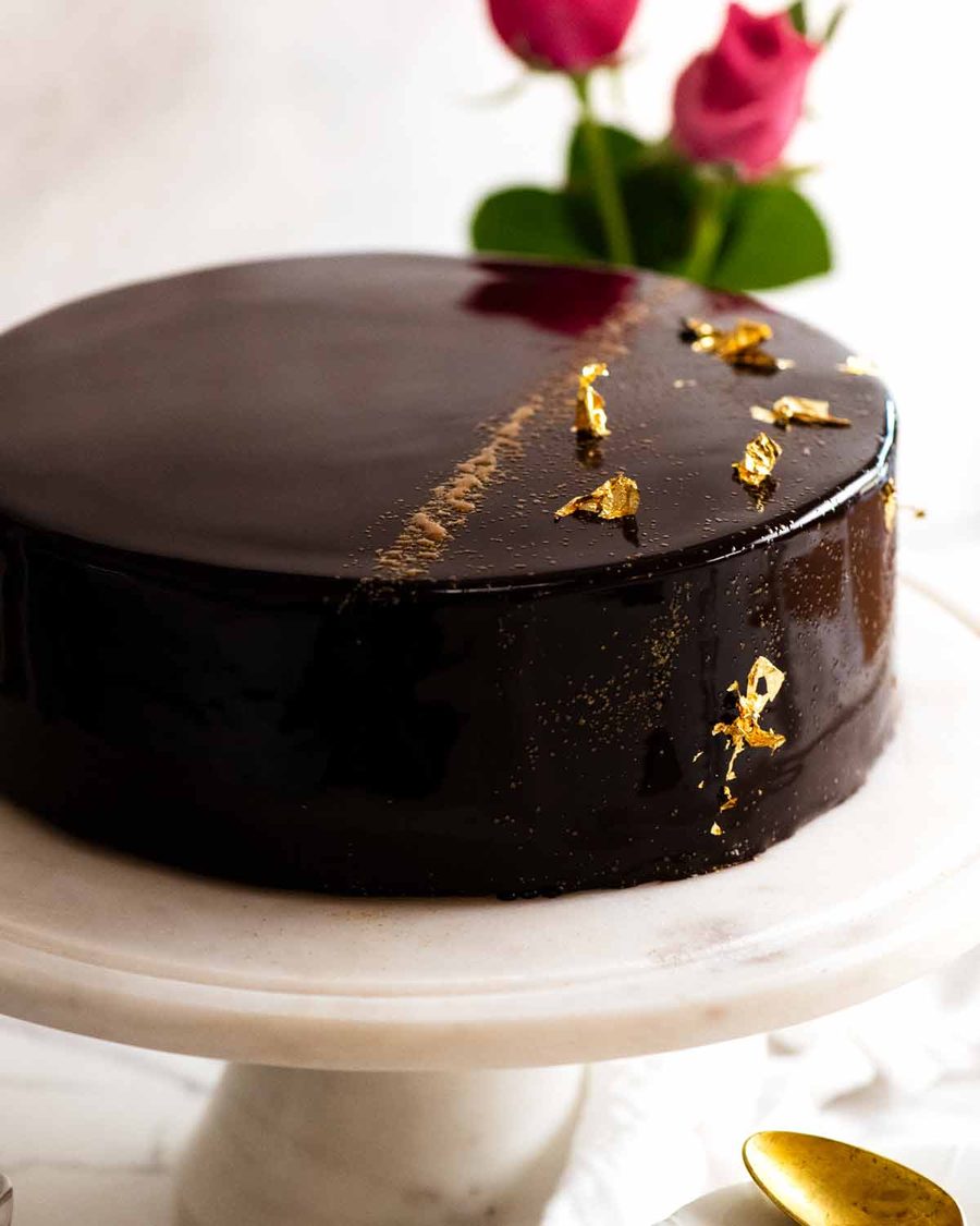 Chocolate Mirror Glaze Cake on a cake platter, ready to be served
